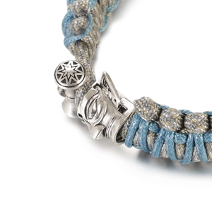 Detailed macro view of woven paracord bracelet with ornate silver mythical beast buckle