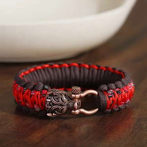 Detailaufnahme von geflochtenem Paracord-Armband mit Drachenkopf-Metallverschluss und Schnalle