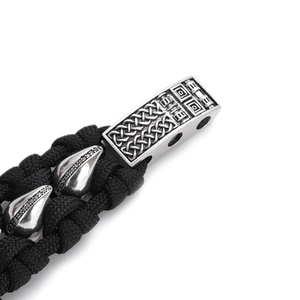 Makroaufnahme: Geflochtenes Herrenarmband mit graviertem Keltenknoten und schwarzen Zirkonia
