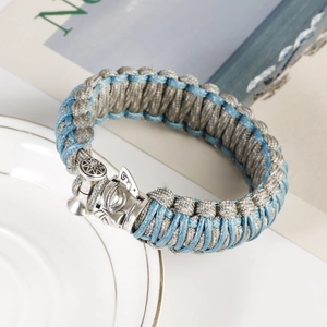 Detail of blue braided paracord bracelet with a vintage silver Norse hammer clasp