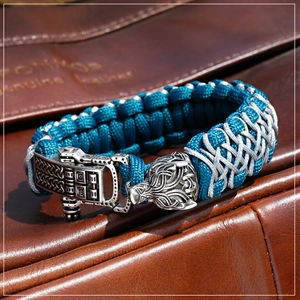 Macro shot of a braided paracord bracelet featuring a silver dragon head metal clasp