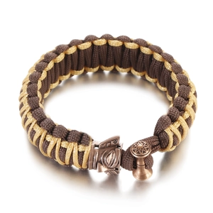 Detailed close-up of a hand-woven paracord bracelet with a bronze animal head metal ornament