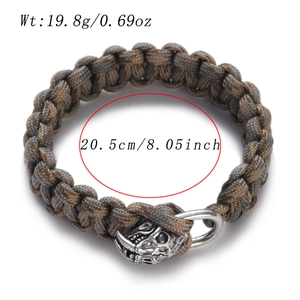 Detailed view of gray-brown paracord bracelet with silver skull charm and metal shackle