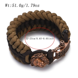 Detail of outdoor woven men's bracelet featuring bronze lion head and engraved buckle