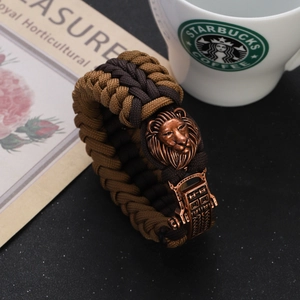 Detail of vintage braided paracord bracelet with bronze lion head and mechanical clasp