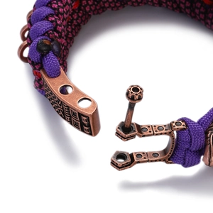 Macro shot of purple and black paracord bracelet featuring a bronze celtic shackle clasp
