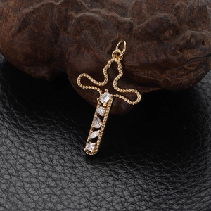 Detailed view of a gold cross pendant featuring vintage beadwork and clear zircons