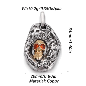Detail of vintage gothic skull pendant with orange gemstone eyes and engraved trust text