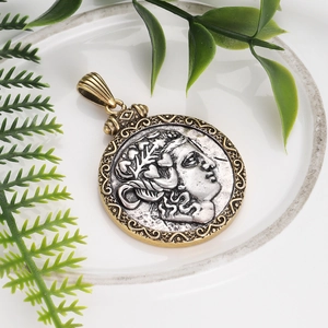 Macro detail of vintage Roman bronze coin pendant with silver portrait carving
