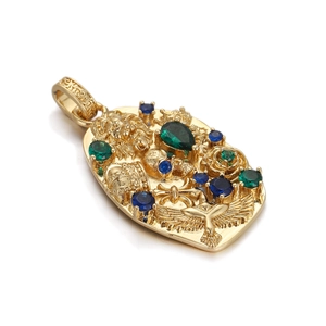 Macro view of gold pendant featuring lion, skull, and colorful inset gemstones