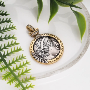 Macro detail of vintage Roman bronze coin pendant with silver goddess relief and crystals