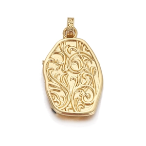 Close-up of vintage gold locket with intricate floral engraving and 18K finish
