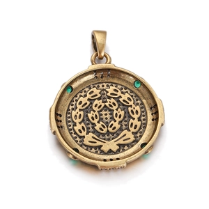 Close-up of vintage bronze roman coin pendant with green gemstones and laurel wreath