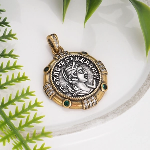 Detail of two-tone vintage coin pendant with green gemstones and classic relief