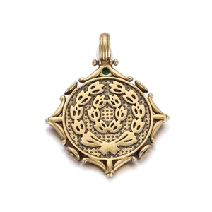 Macro detail of vintage bronze Roman coin pendant with green gemstone and bow accent