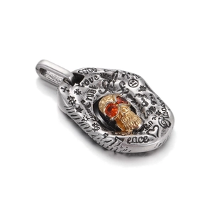 Detail of vintage punk skull pendant with orange stones and engraved graffiti text