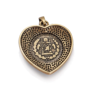 Detail of vintage heart-shaped bronze pendant with Afghan national emblem relief engraving