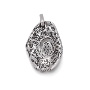 Macro shot of silver vintage hip hop pendant with engraved love peace symbols