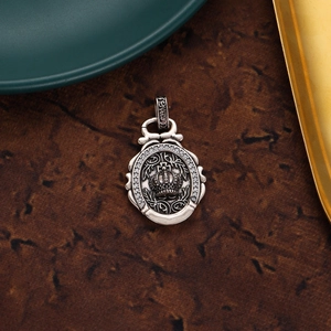 Detailed macro view of vintage crown pendant with sparkling zircons and aged silver finish