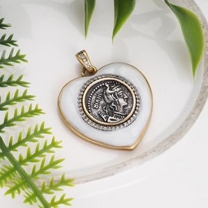 Macro view of heart-shaped gold pendant with Roman portrait and sparkling crystals