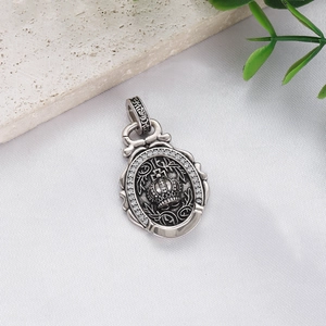 Macro shot of vintage crown pendant with white zircons and intricate filigree details