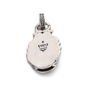 Macro shot of retro silver skull pendant back with crown engraving and gothic scrollwork bail