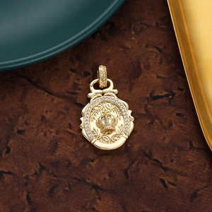 Detailed close-up of a gold oval crown pendant with sparkling crystals and relief