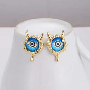 Detailed macro shot of Devil's Eye stud earrings with blue drip effect on a white stand