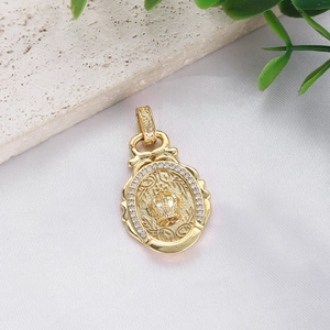 Macro shot of gold-plated crown pendant with cubic zirconia inlay and scroll textures
