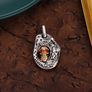 Macro shot of gothic skull pendant with red zircon eyes and engraved metal details
