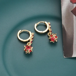 Macro shot of gold-plated hoop earrings featuring red zircon stones and hollow sphere drops