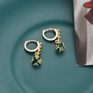 Detail of 18K gold-plated drop earrings featuring green zircon stones in a cage design