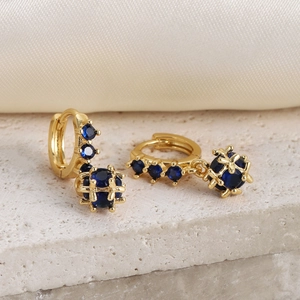 Macro view of 18K gold plated hoop earrings with blue zircon spheres on stone