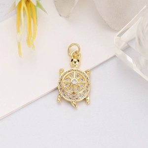 Macro view of gold turtle pendant featuring nautical wheel design and cubic zirconia
