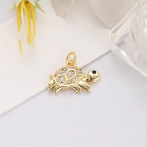 Detailed macro view of a gold-plated turtle pendant with shimmering white zircon stones