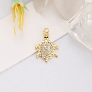 Macro view of gold sea turtle pendant with sparkling cubic zirconia and hanging loop