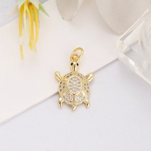 Detailed close-up of a gold-plated turtle pendant with sparkling cubic zirconia inlay