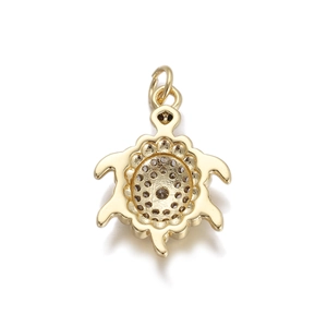 Macro detail of a turtle pendant with bright gold plating and sparkling zircon stones