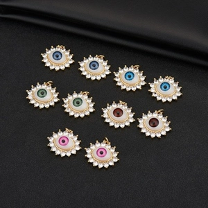 Detailed view of evil eye jewelry charms with colorful pupils and crystal zircons