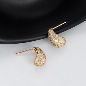 Makroansicht goldener Halbmond-Ohrstecker mit weißem Zirkonia-Mikropavé für Damen