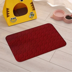 Red coral fleece pet mat with round quilted pattern on light wooden floor for dogs and cats