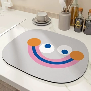 Absorbent kitchen draining mat with minimalist cartoon face on marble countertop