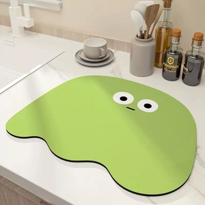 Cartoon green absorbent kitchen draining mat with cute face on marble countertop