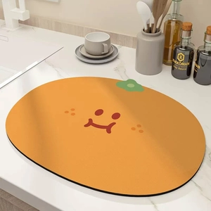 Detail of orange kitchen drying mat with smiley face on marble countertop