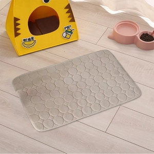 Close-up of gray quilted coral fleece pet mat on wooden floor with pet accessories