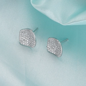 Detailansicht der silbernen Zirkonia-Ohrstecker mit Mikropavé auf hellblauem Satin-Hintergrund