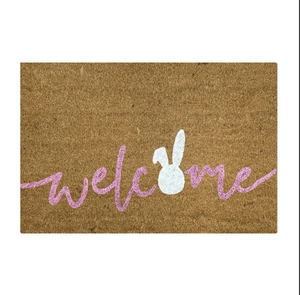 Detail of coconut fiber texture on doormat with welcome text and white rabbit silhouette