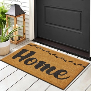 Brown coir door mat with black Home lettering and vine pattern on white deck