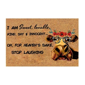Detail of coir door mat featuring a cow with leopard glasses and fun quote