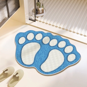 Blue foot-shaped bathroom mat with white footprint pattern on a stone floor